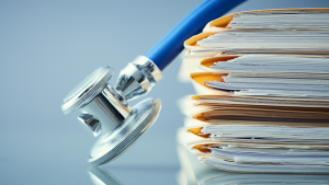 Stethoscope resting beside a stack of medical files representing the importance of medical records in personal injury cases.